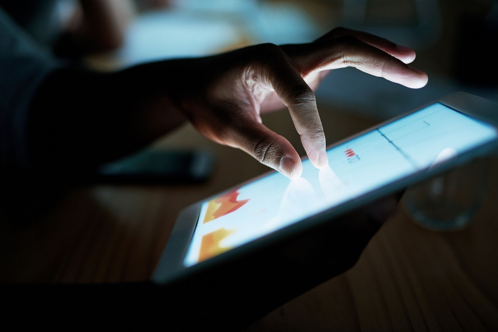 A close-up of a businesswoman’s hand using a digital tablet, symbolizing the use of technology for effective risk mitigation in a business setting.