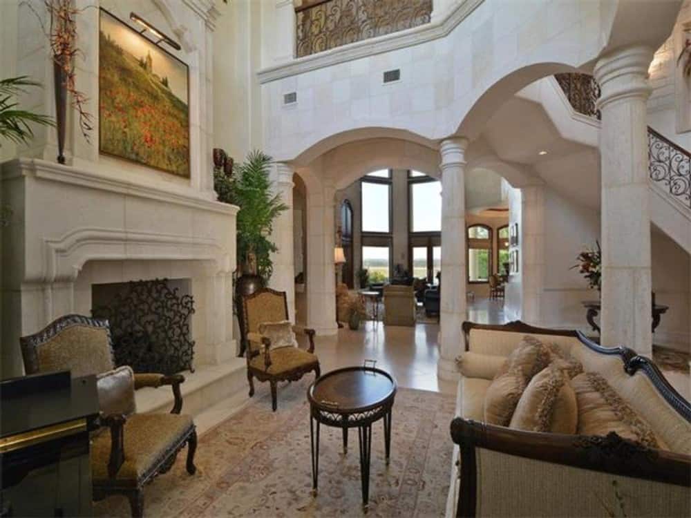 Living room with a fireplace and classy seats paired with a small round coffee table.