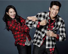 Shin Min Ah and kim woon bin wearing a check shirt and a black trouser holding each other 