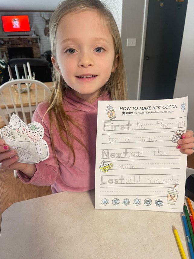 Child showing off their writing at home