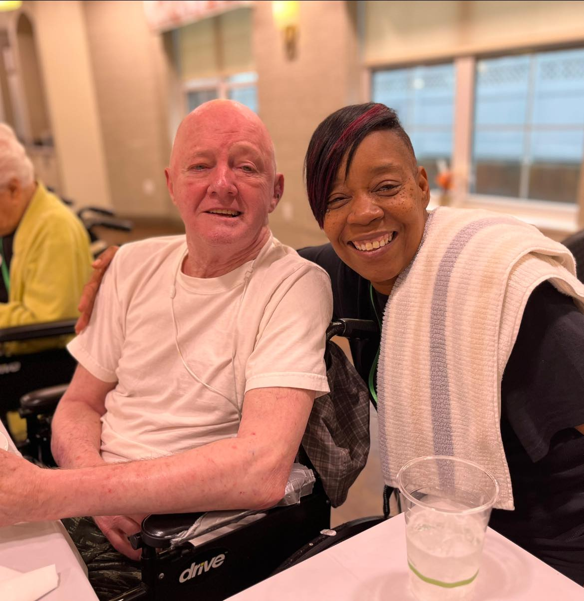 Picture of caregiver and resident smiling at the camera