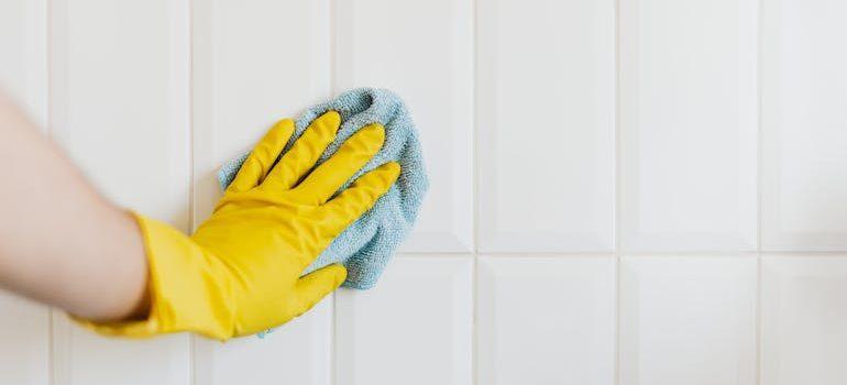 a close-up of a hand cleaning tiles