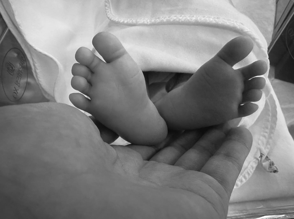 A picture of Hyun Bin hand and his baby's leg 