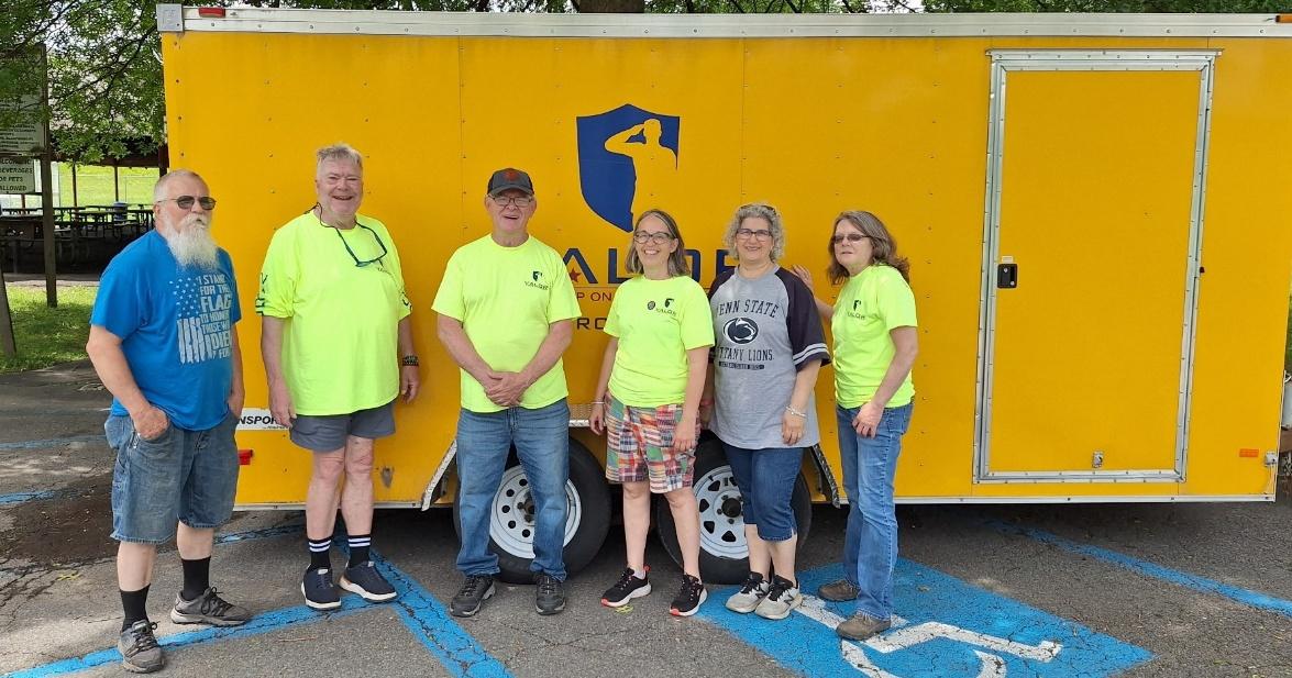 A group of people standing in front of a yellow truck

AI-generated content may be incorrect.
