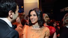 This contains an image of Vanity Fair's Editor-in-Chief Radhika Jones standing next to a man in a tuxedo at a formal event