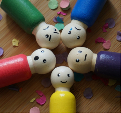 A group of wooden peg people with faces on top of each other

AI-generated content may be incorrect.