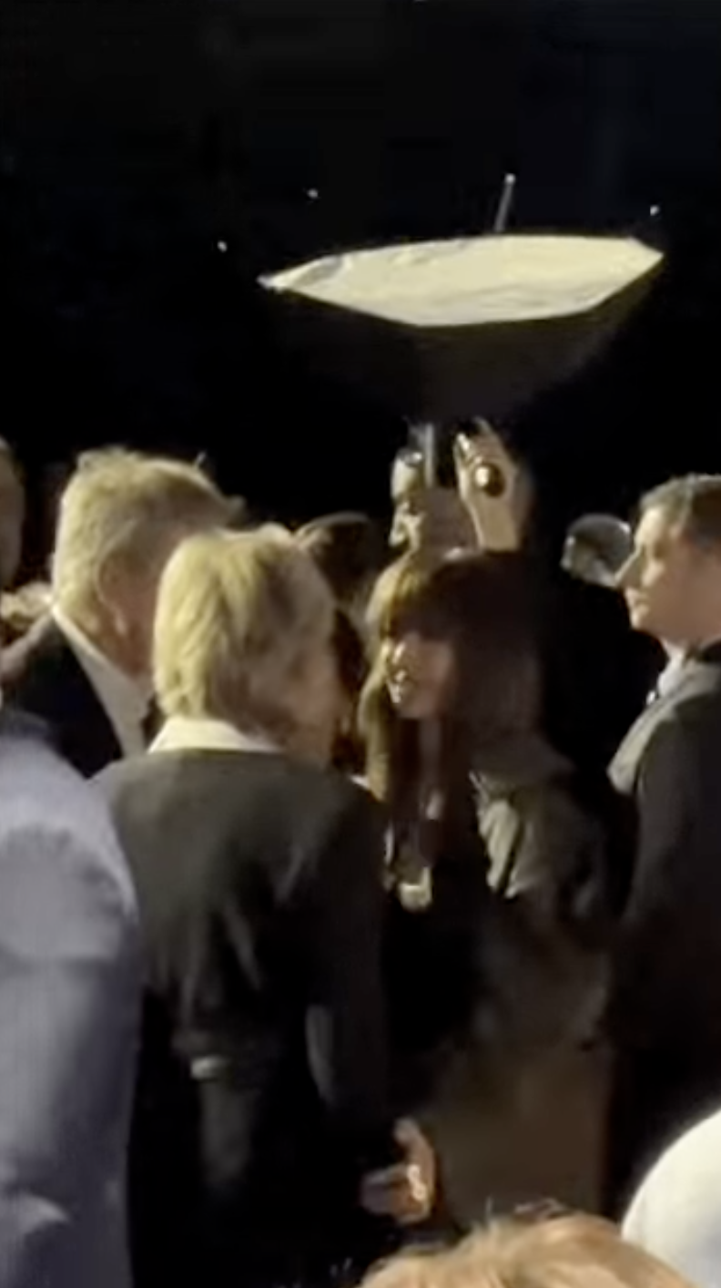 A picture of BLACKPINK Lisa spotted talking to Bernard Arnault and his wife, Hélène Mercier with her hand on Hélène Mercier shoulder 