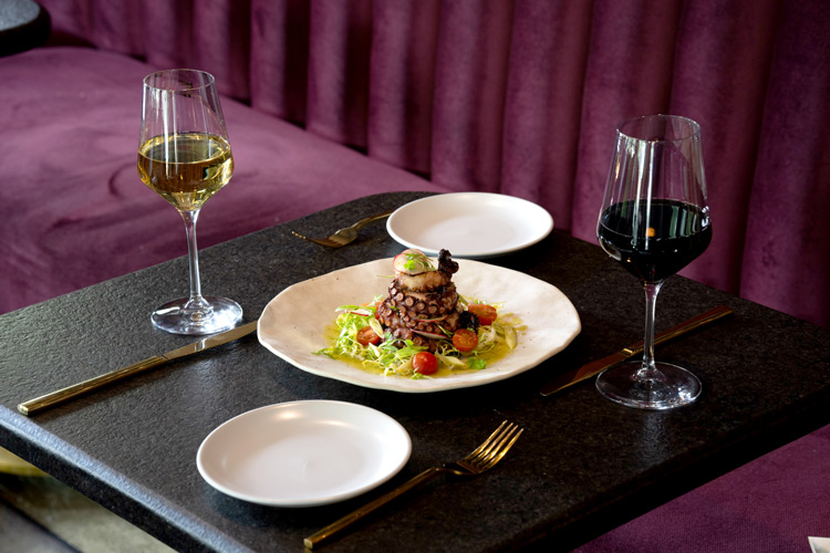 two glasses of wine accompanying an octopus dish