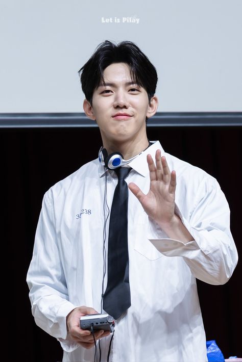 A picture of  DAY6's Dowoon wearing white with a phone on his hand 