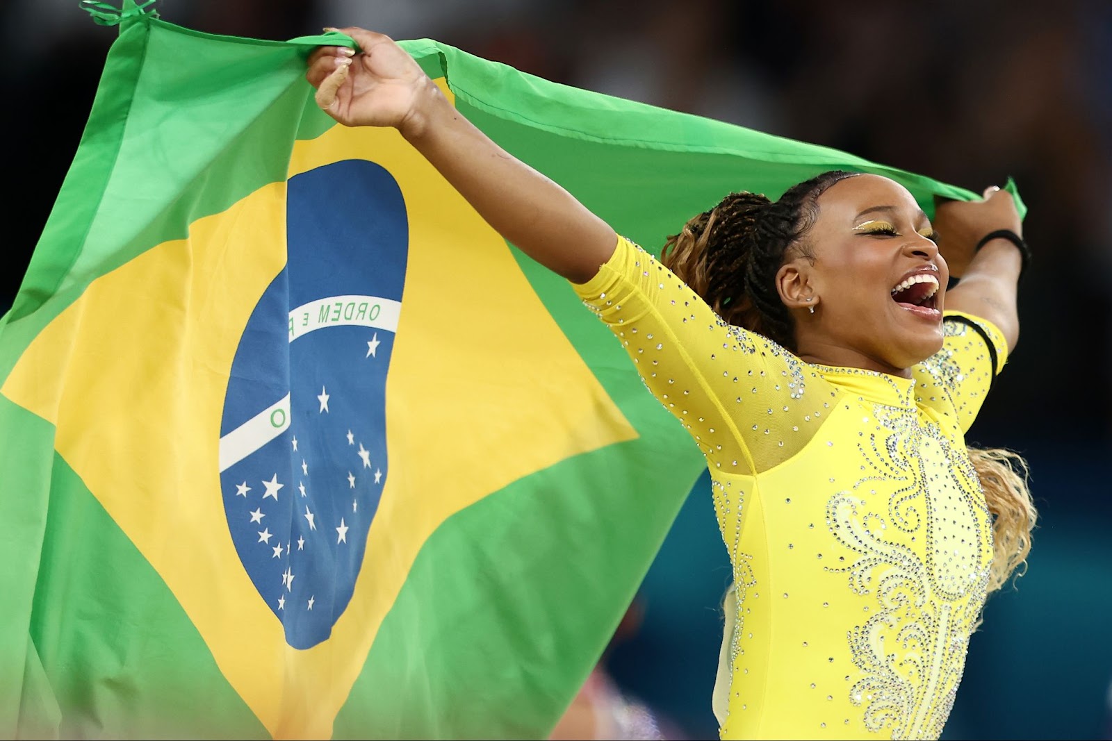 Rebeca Andrade com a bandeira do Brasil após competições nas Olimpíadas de 2024, em Paris