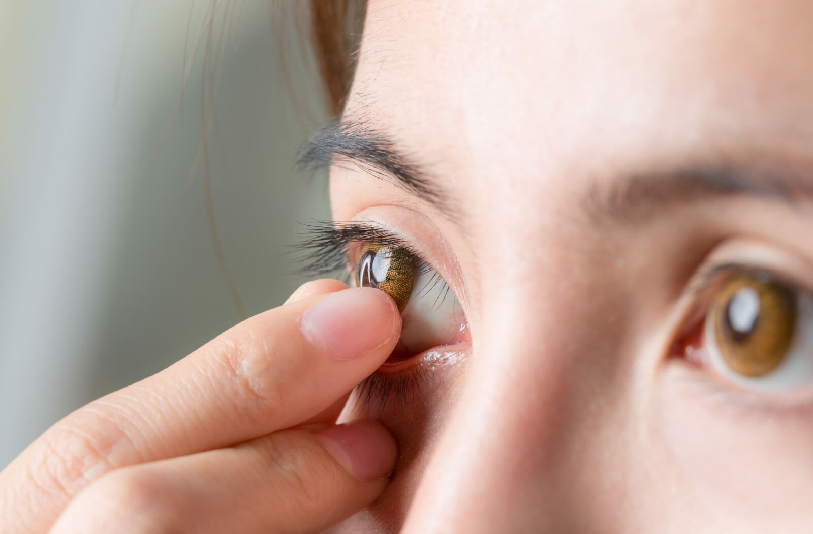 A close-up image of a person touching a stuck contact lens is their right eye.