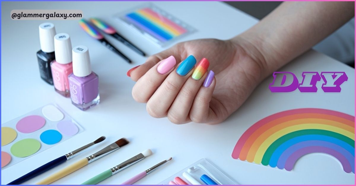 Hand with multicolored nails, nail polish bottles, brushes, and rainbow stickers on a table.