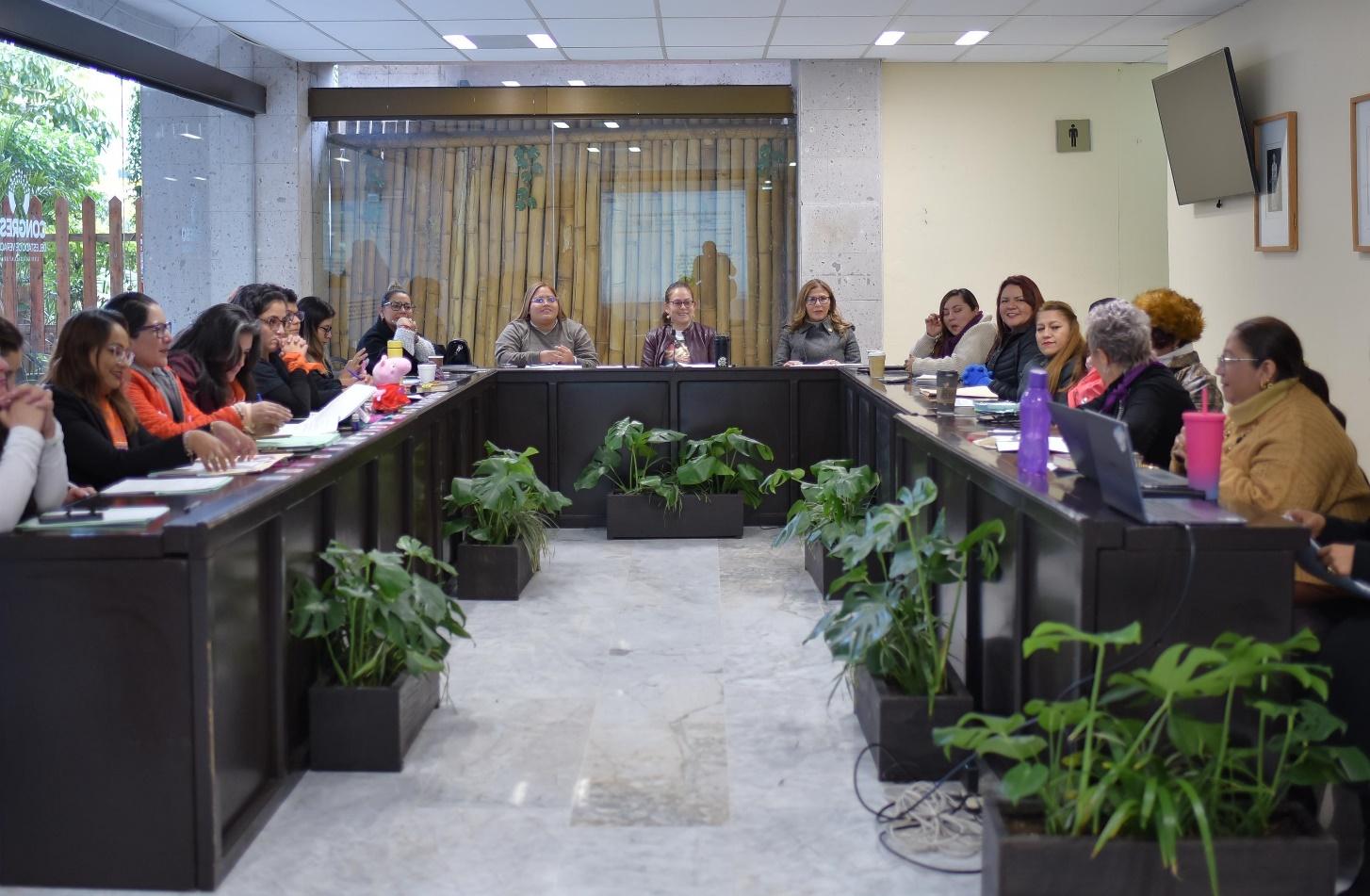 Un grupo de personas sentadas en una mesa junto a una ventana

Descripción generada automáticamente