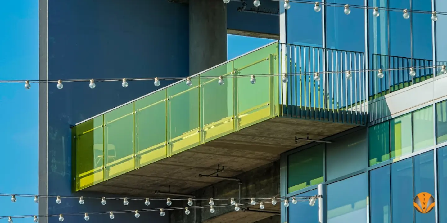 An image of a yellow customized glass railing system on a balcony. 