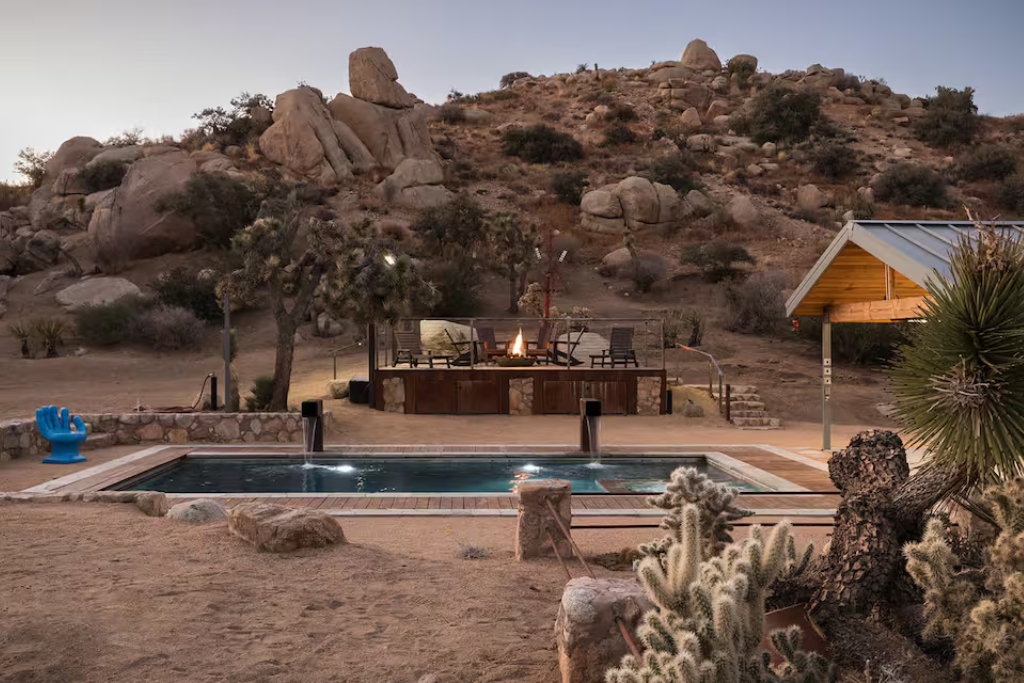 desert airbnb with a built in pool fire pit rocks and panoramic view of the desert