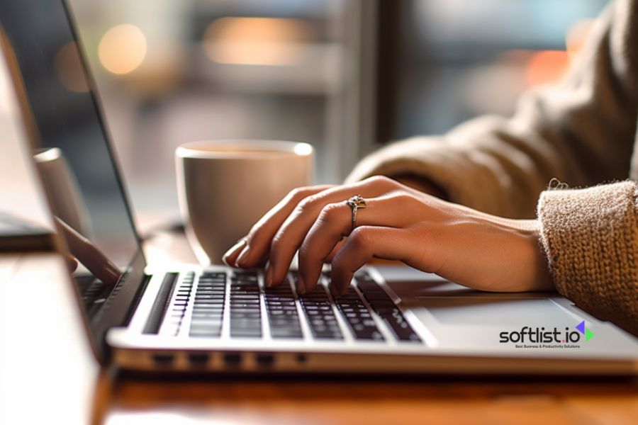 Person typing on laptop with coffee cup