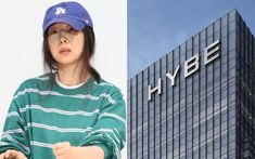 This  contain an image of Min Hee Jin standing in front of a building with the hybe logo on it