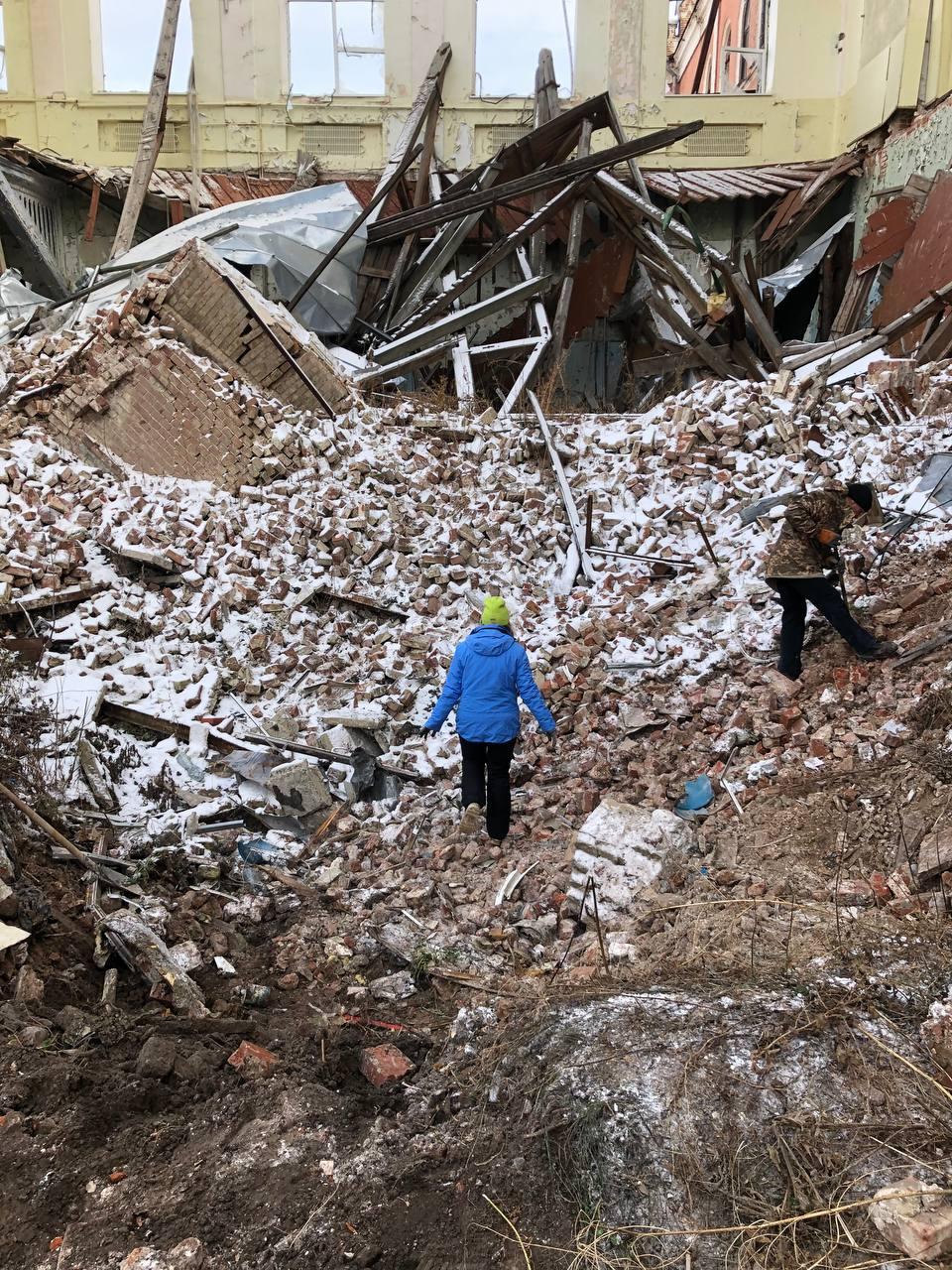 People walking in a pile of rubble

Description automatically generated