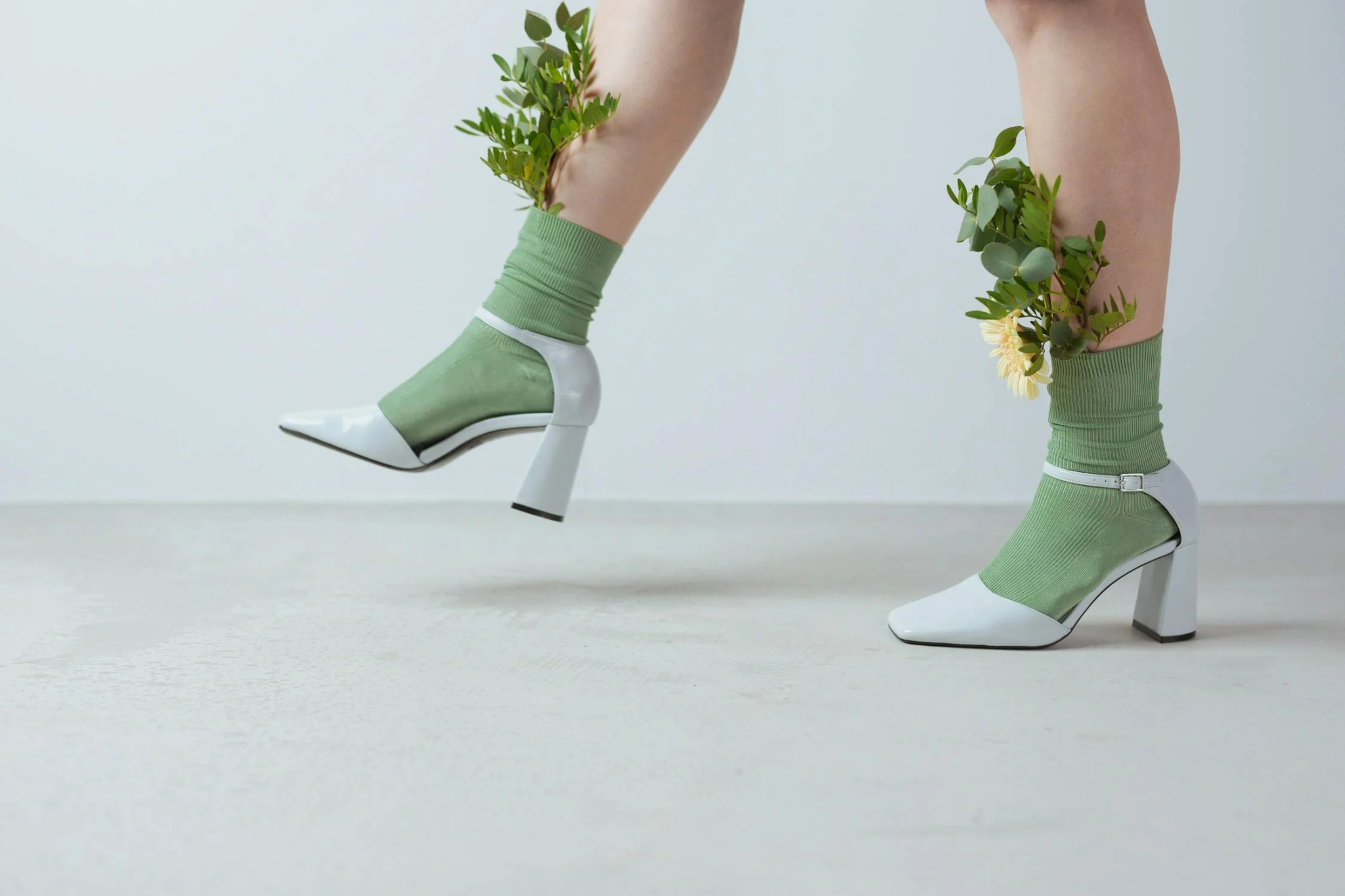 Close-up of legs wearing stylish green compression socks paired with fashionable shoes, blending comfort and style effortlessly.