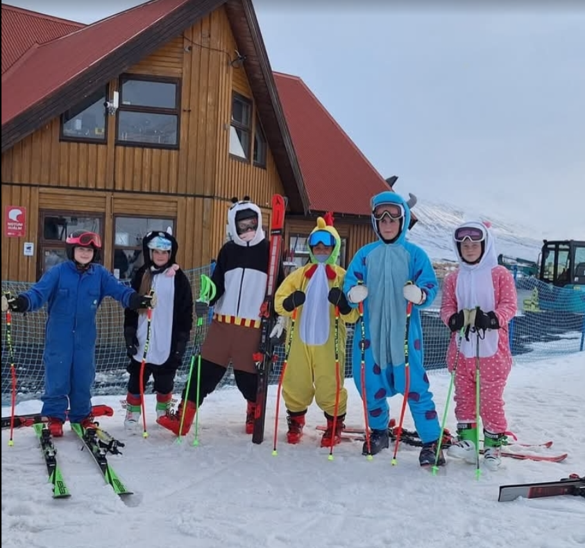 A group of people in clothing standing in the snow
AI-generated content may be incorrect.