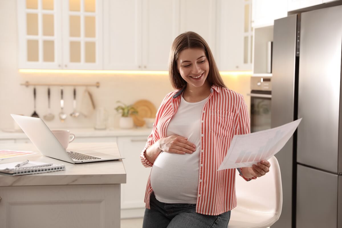 Pregnant woman looking at a graph at home