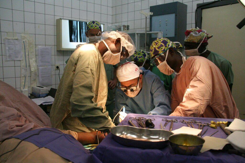 A group of surgeons performing a surgery

Description automatically generated