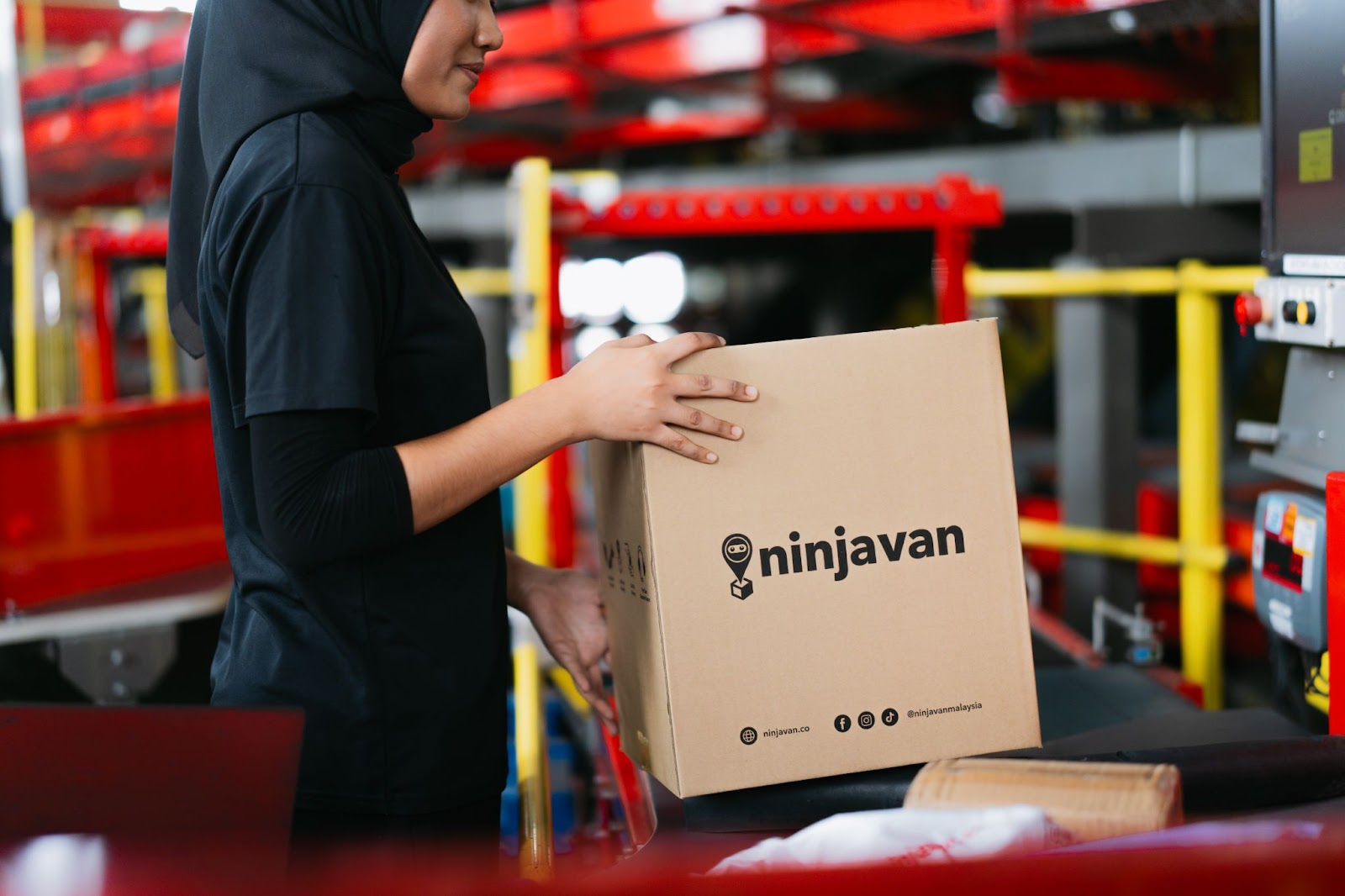 Close-up of Ninja Van staff packing FMCG products into boxes for shipping to customers.