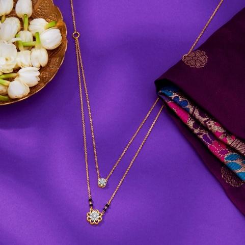 A gold necklace with a flower and a bowl of flowers

AI-generated content may be incorrect.