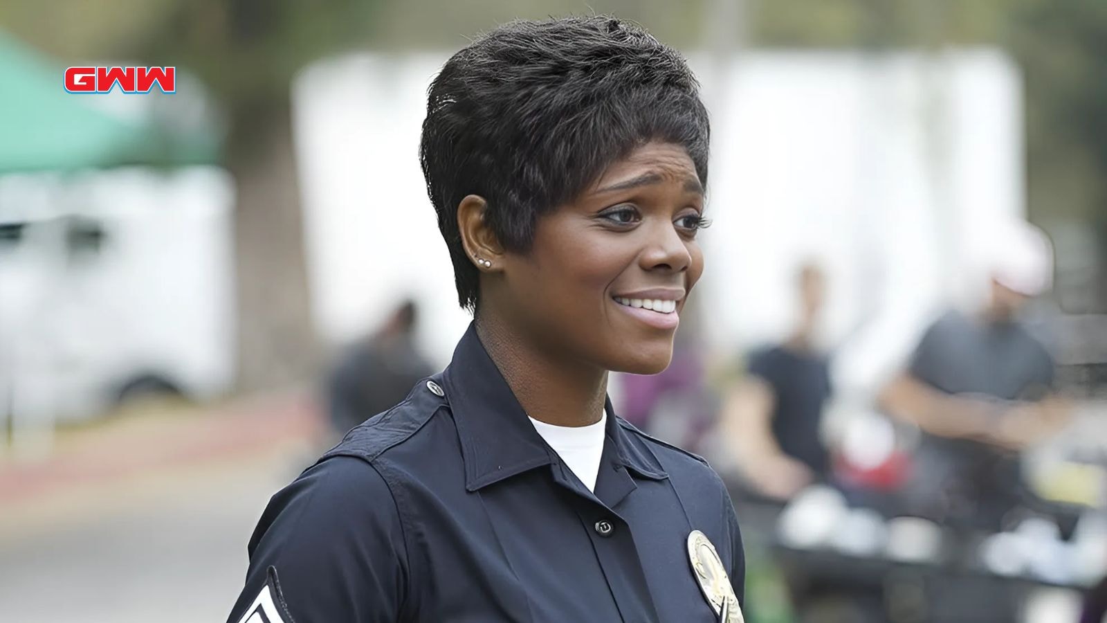 Mekia Cox as Nyla Harper, smiling in her LAPD uniform during a moment of levity or camaraderie