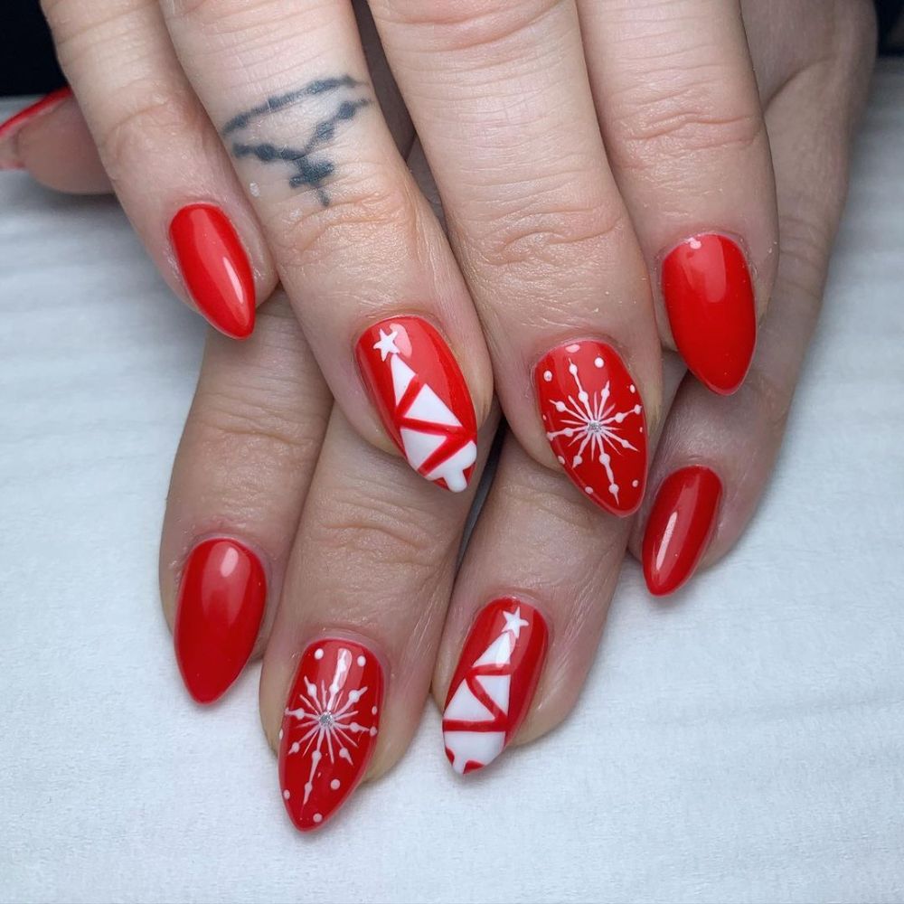 Close up of hands having Christmas red nails with Christmas Tree Charm Nails