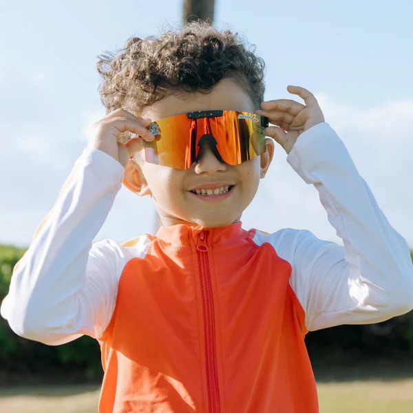 Boy with sunset UV-protective sunglasses by SwimZip—Polarized vs non-polarized sunglasses