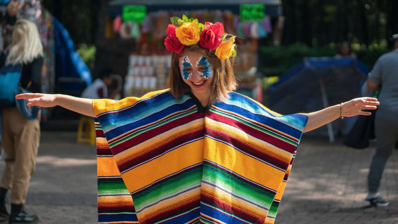 Mujer con un colorido poncho y flores en la cabeza