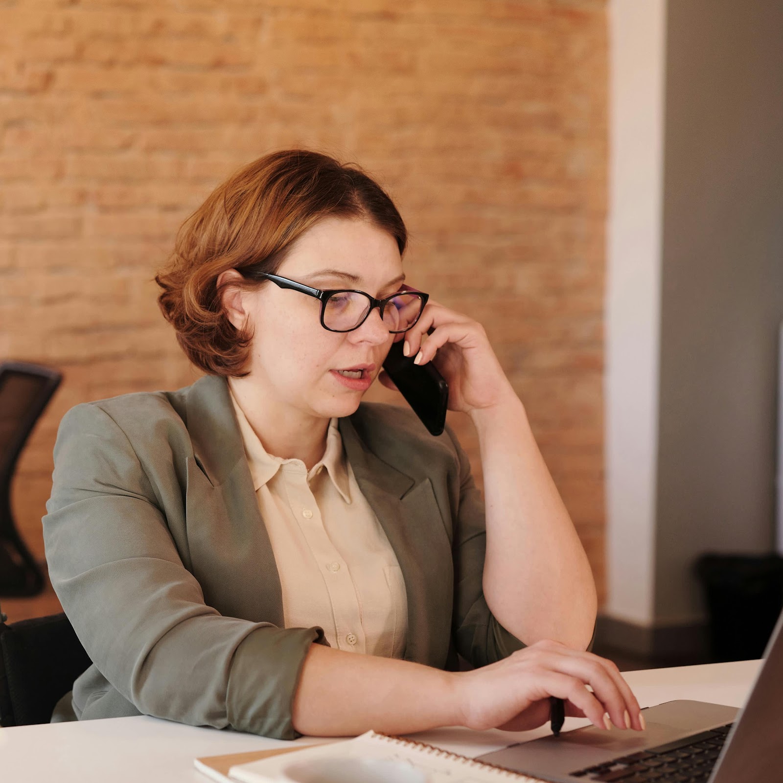 A woman on a call in a work environment | Source: Pexels