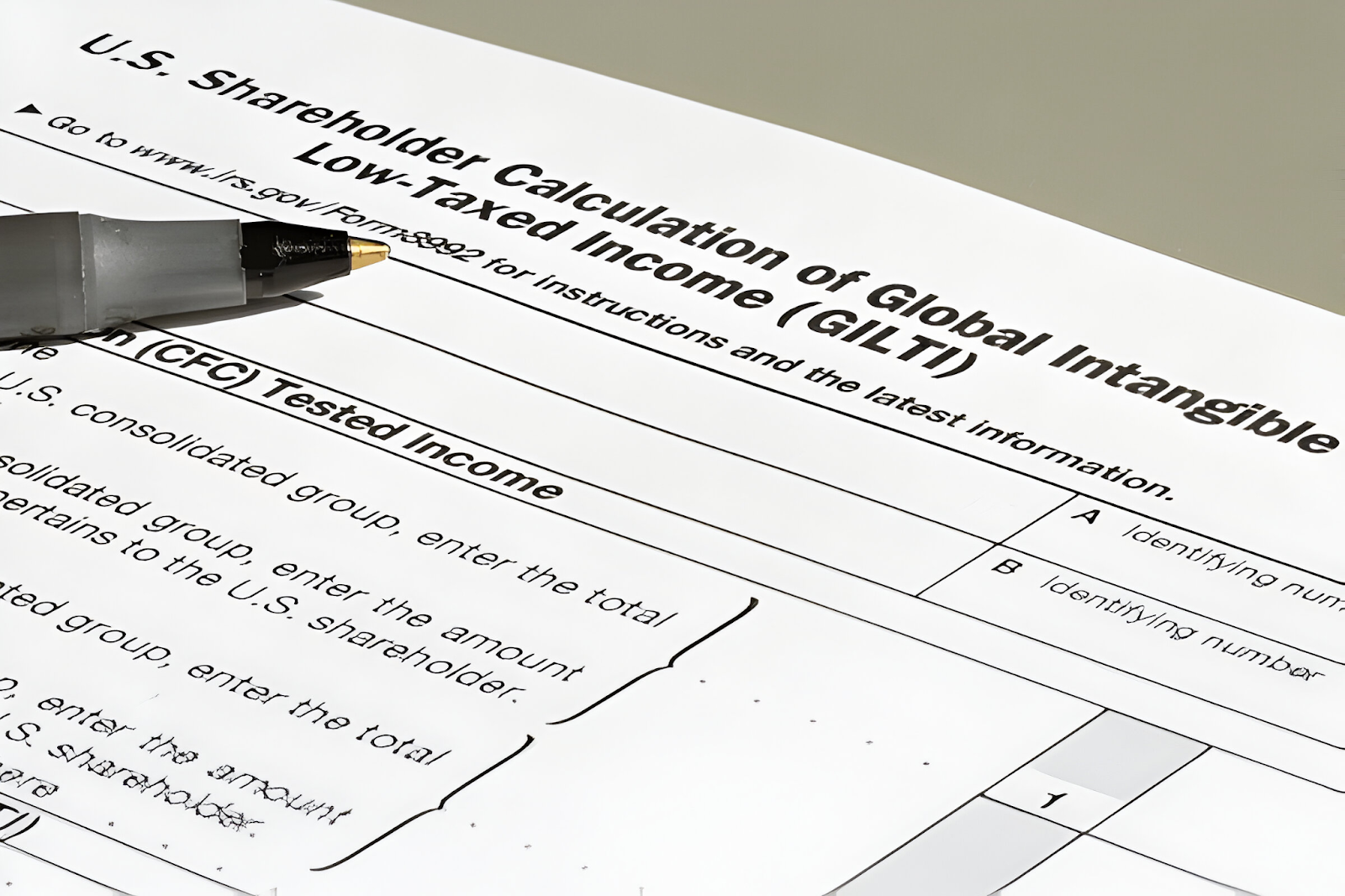 Form for U.S. Shareholder Calculation of Global Intangible Low-Taxed Income (GILTI) with a pen, illustrating how accountants handle international tax issues.