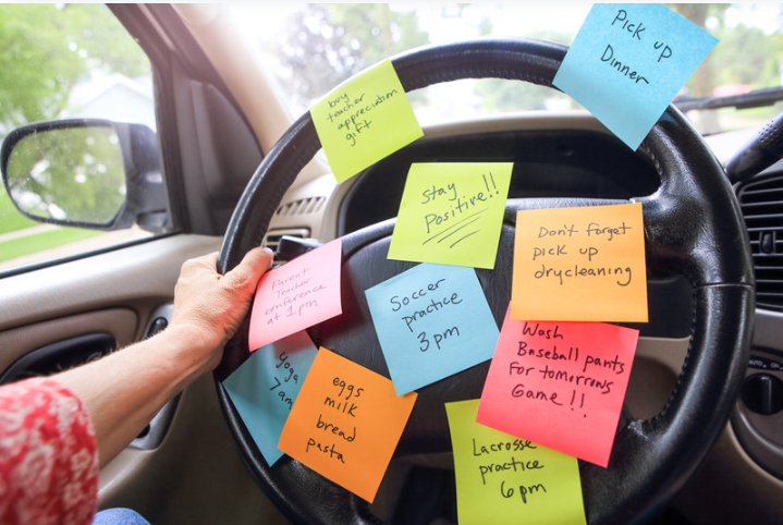 Car steering wheel covered with sticky notes, illustrating time blocking for organizing daily tasks and reminders