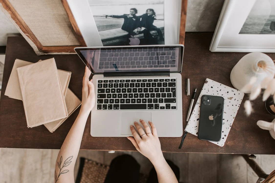 Overhead view of a person working on a laptop at a cozy desk.