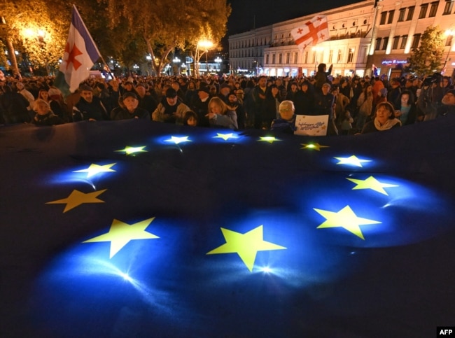 Проевропейский митинг прошел на центральной площади Свободы в Тбилиси 20 октября. Десятки тысяч демонстрантов размахивают флагами ЕС и Грузии и держат плакаты с "Грузия выбирает Европейский Союз". Фото AFP