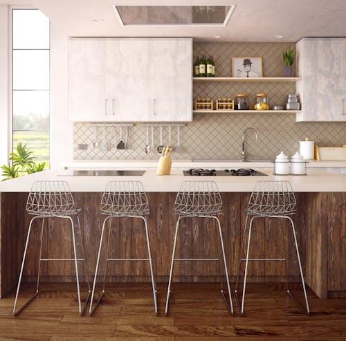 Free Chic minimalist kitchen design featuring wooden accents and modern bar stools. Stock Photo