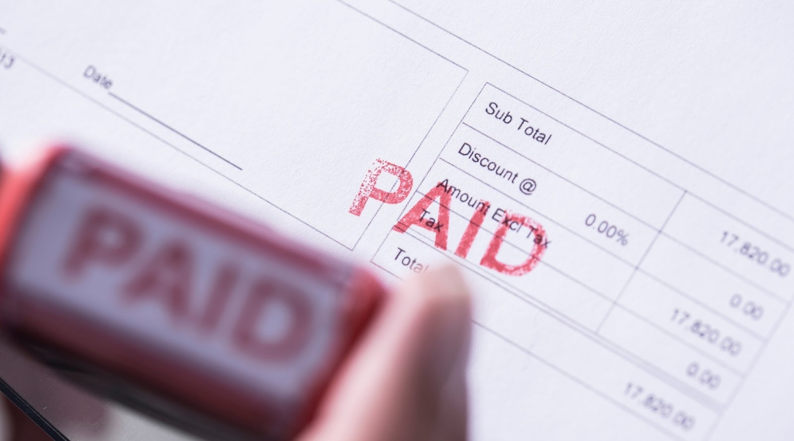 Close-up of a stamped invoice marked "PAID" in red ink.