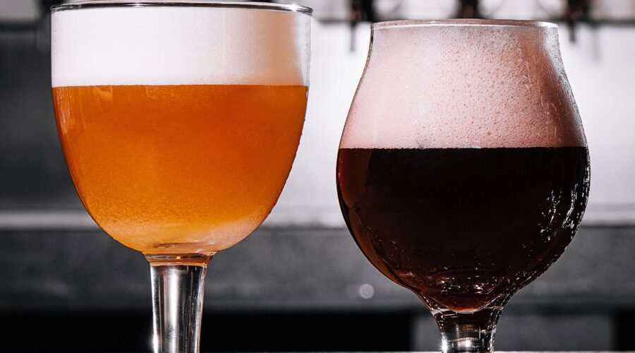 Close-up shot of two glasses of beer with foamheads.