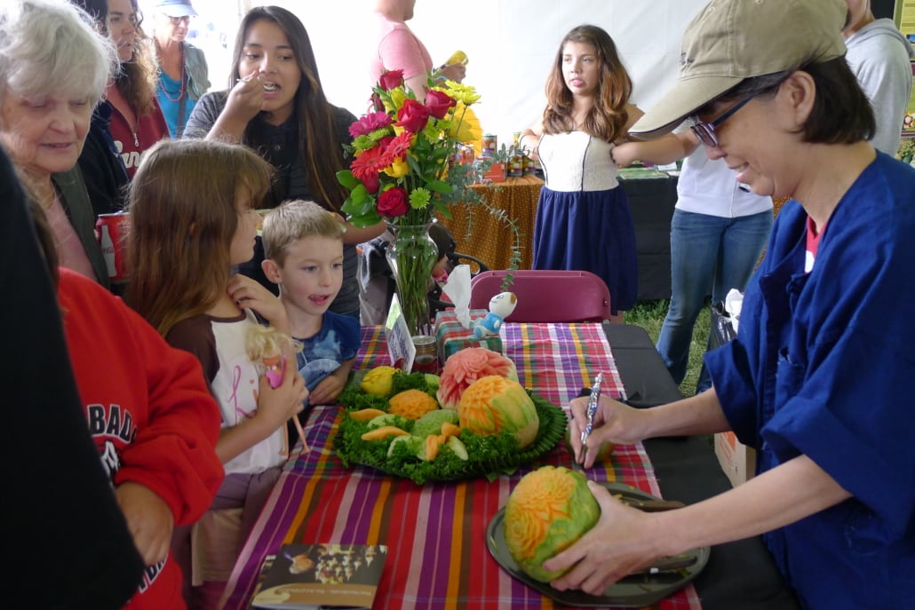Kids having fun with fruit artwork at the festival.