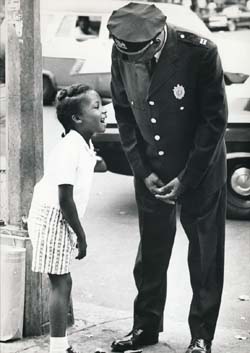 Lloyd Sealy is leaning down to talk to a young girl, who is laughing.