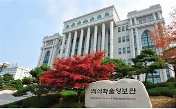 A large white building with columns and a red tree

AI-generated content may be incorrect.