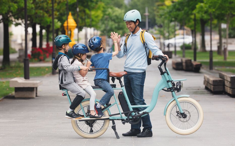 A large family enjoying a rented cargo bike to explore Paris.