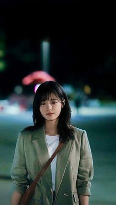 This contains an image of Go Bo Gyeol wearing a gray jacket and a white inner shirt with a brown bag across her shoulder 