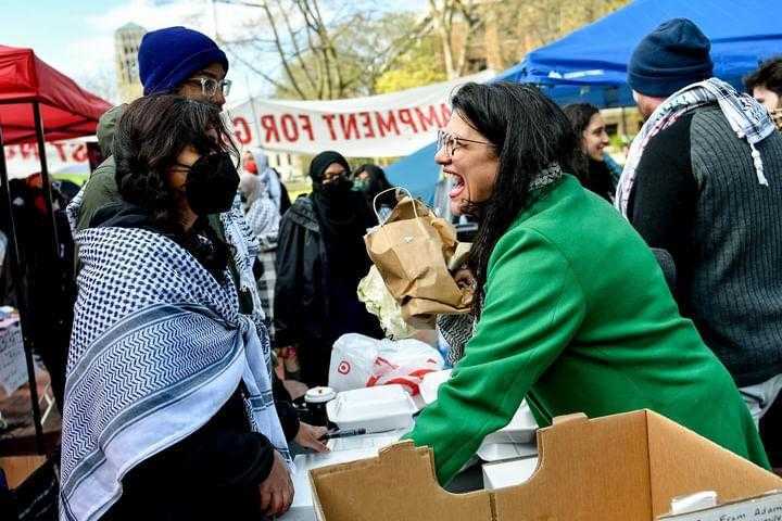 Rashida stands at a table in at a gaza protest