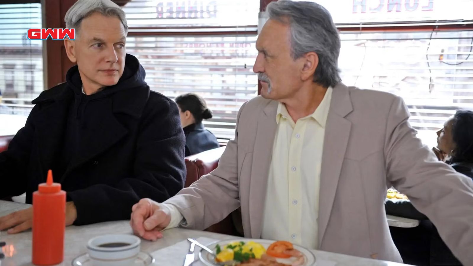 NCIS Origins: Muse Watson as Mike Franks and Mark Harmon as Gibbs talking in a diner