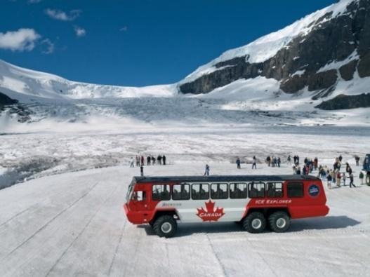 A truck is parked on the side of a snow covered mountain

Description automatically generated