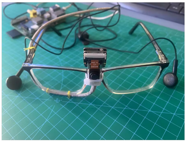 A pair of glasses with wires on a green surface

Description automatically generated