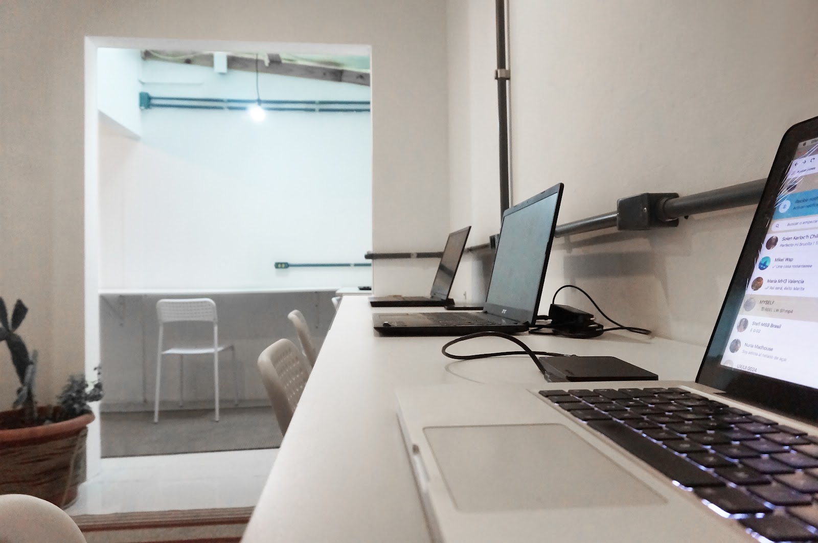 Imagem com foco em computadores na estação de trabalho do cowork